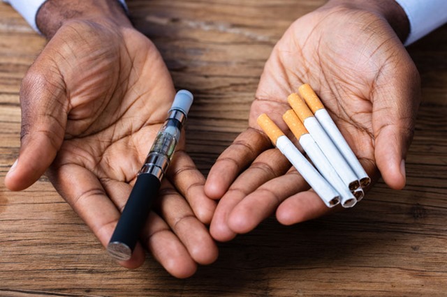 man holding a vape pen and cigarettes thumb - 【VAPE】電子たばこ関連の肺障害、原因は酢酸ビタミンＥ？　米疾病対策センターが着目